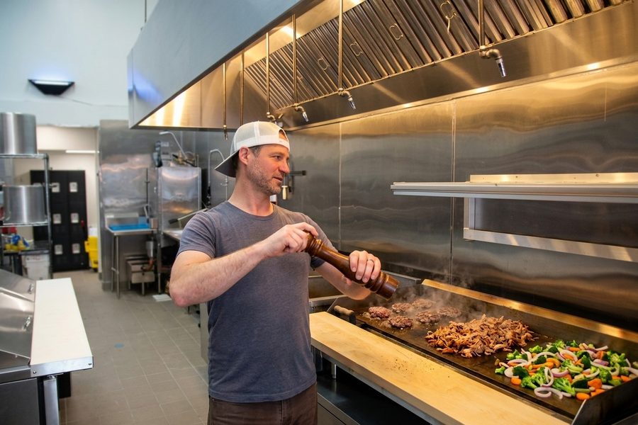 Executive Chef Martin Damyan cooking on the grill at UpperCut restaurant kitchen, Forest Hill SF
